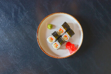 Japanese seafood sushi set on black background served in a white round plate. Traditional Japanese cuisine concept.
