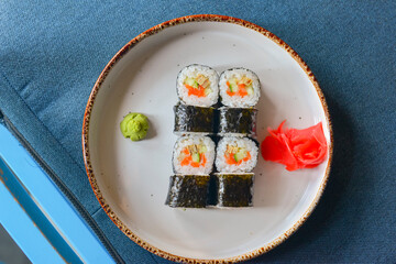 Japanese seafood sushi set on black background served in a white round plate. Traditional Japanese cuisine concept.