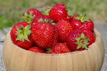 Mature strawberries in a bamboo bowl close-up