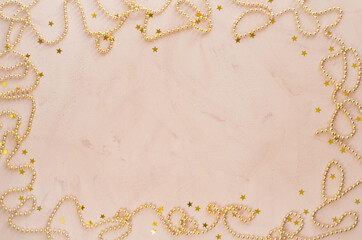 Golden Christmas background. Beads with decorative balls and stars.