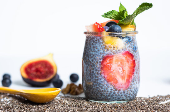 Primer plano de esayuno de chia con fresas, ar&aacute;ndanos y decorado de higo y semillas de chia