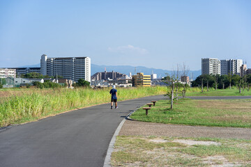Fototapeta premium 空いている公園の散歩道を、蜜を避けて一人でウォーキングする男性