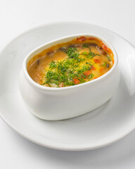 Roasted vegetables, potatoes, mushrooms and cheese in a pot. Baked dinner in a white pot. Delicious meal for dinner.