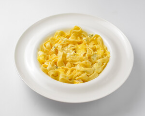 Delicious vegetarian dish of pasta with cheese served in a white plate over white background.