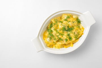 Ravioli dumpling with fresh greenery served in a white pot over white background. Isolated on white.