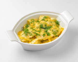 Ravioli dumpling with fresh greenery served in a white pot over white background. Isolated on white.