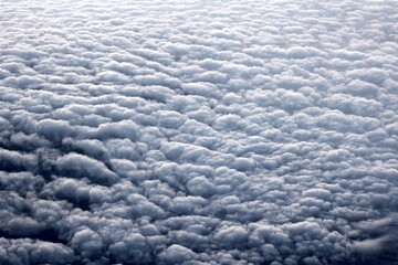view of fluffy clouds from the plane window