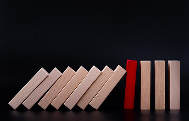 Red wooden block stopping the domino wooden effect. Alternative risk concept, business plan and...