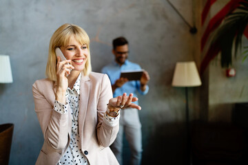 Business lady answering the phone with a smile, receiving good news in office