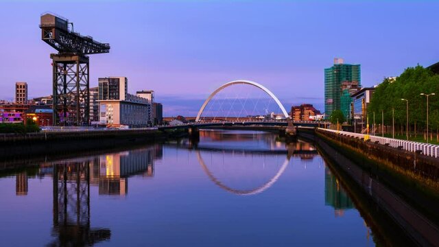 Glasgow, Scotland. View of Glasgow, UK landmarks - Finnieston Crane and Squinty bridge at sunset. Time-lapse with the colorful twilight sky, zoom in
