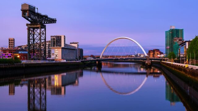 Glasgow, Scotland. View of Glasgow, UK landmarks - Finnieston Crane and Squinty bridge at sunset. Time-lapse with the colorful twilight sky, panning video
