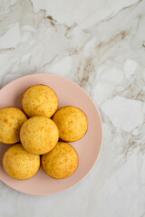 Homemade Cornbread Muffins on a pink plate, top view. Flat lay, overhead, from above. Space for text.