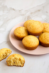 Homemade Cornbread Muffins on a pink plate, side view. Copy space.