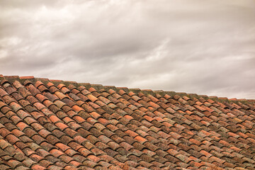 Roof of a house with cloudy sky.