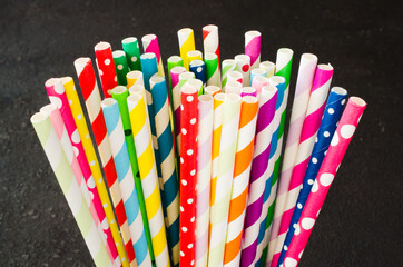 Fototapeta na wymiar Colorful paper straws of different colors for cocktails and drinks on dark background.