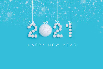 2021 New Years numbers made of white artificial snow and balls on a blue background