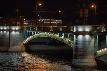 Illuminated bridge over the river at night. Blurry background photo. View of Saint Petersburg.