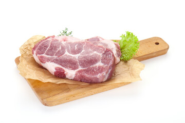 Raw pork steak over wooden board