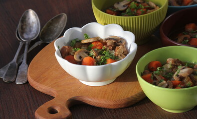 Meat stew with vegetable in bowl on rustic wooden background