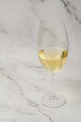 white wine in glass on marble background.