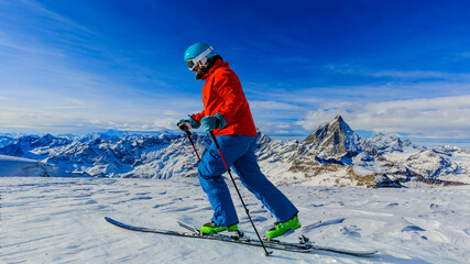 Man skitouring on fresh powder snow with Matterhorn in background, Zermatt in Swiss Alps.