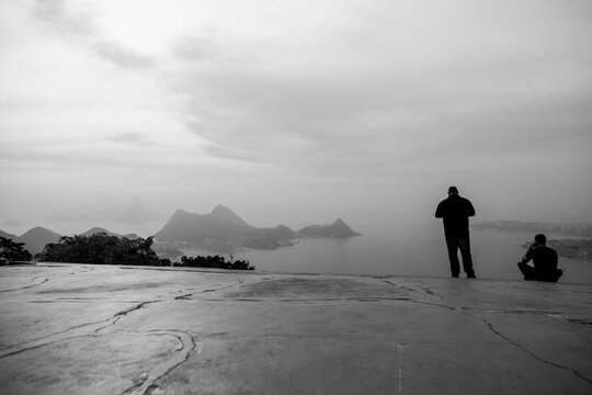 Grayscale Back View Of People Looking Out Over The Ocean