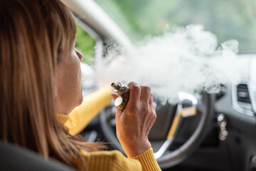 Woman smoking an e-cigarette in car