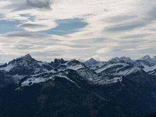 Obraz na płótnie Canvas Panorama-Blick über die schneebedeckten Alpen in Tirol in Österreich bei guter Fernsicht und leicht bewölktem Himmel