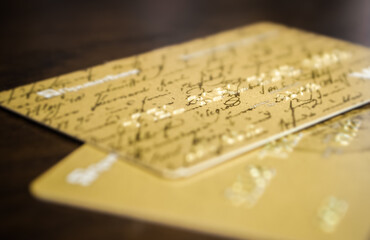 Close-up of two golden credit cards located on a table. - 389827870