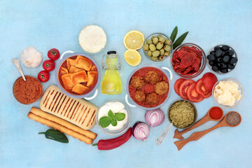 Italian food ingredients for a healthy lifestyle low in cholesterol & high in antioxidants, anthocyanins, fibre, lycopene, omega 3 & protein. Flat lay, top view on mottled blue background.