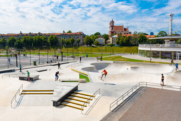 New skateboard park, skate park, skating rink in the city center with kids or children playing 