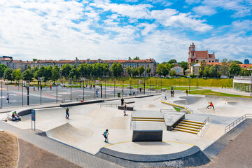 New skateboard park, skate park, skating rink in the city center with kids or children playing 