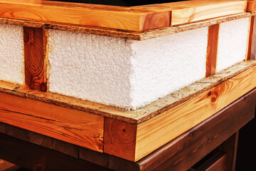 Warming at home. Fragment of a wooden wall with foam insulation. Close-up.