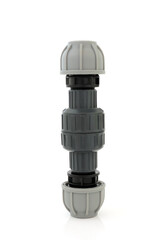 Plastic non return value compression fitting used in plumbing to facilitate the flow of liquid in one direction only, on white background.