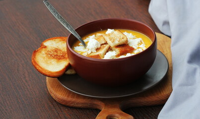 Pumpkin cream soup with a feta cheese, autumn homemade food, dark wooden background. Fodmap diet,vegetarian menu, clean eating recipe