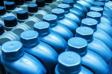 Plastic cans with motor oil. Canisters on a shelf of an auto goods store. View from above. Close-up.