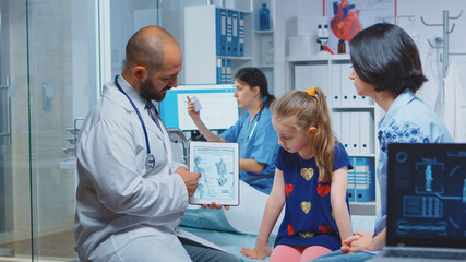 Obraz premium Doctor showing skeleton graphics on tablet during consultation. Healthcare practitioner physician specialist in medicine providing health care service radiographic treatment examination in hospital