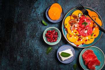 Persimmon carpaccio salad with pomegranate, feta cheese, pink grapefruit and figs