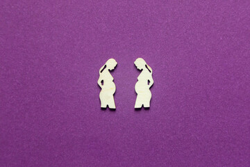 Silhouettes of two pregnant women on a blue background.