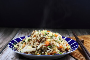 Spicy fried rice with chilly, sliced corn, carrot and onion on the plate. Famous hot and spicy street food menu in Asia. Fast and quick menu in rush hour. 