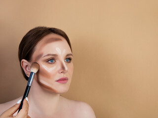 Make-up artist paints a girl. nude shades .Brush in hand