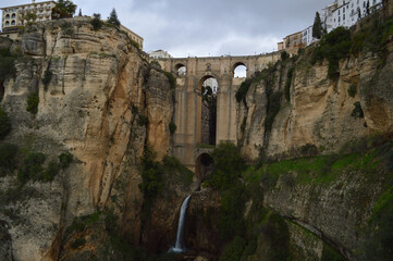 Fototapeta premium Cityscape of Ronda in Spain with Cliffs, Bridge, Andalusian Houses and Waterfall