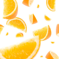 Many orange slices free falling on white background. Selective focus - shallow depth of field.
