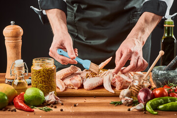 Man brushing chicken wings with French mustard