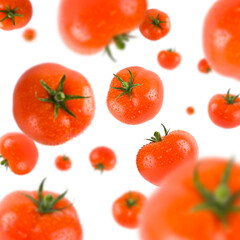 Many red tomatoes free falling on white background. Selective focus - shallow depth of field.