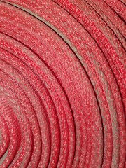 The texture of the twisted red fire hose.