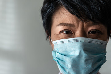 Close-up senior Asian woman wearing protective face during the Coronavirus crisis with a White Background. New normal and hygienic concept