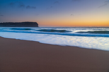 Fototapeta na wymiar Hazy sunrise seascape with low swell