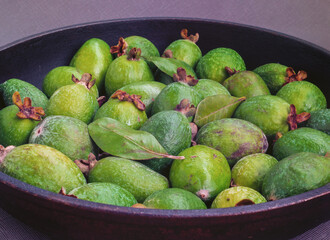 A feijoa fruits (yet known as acca sellowiana) on a dark gray background.
