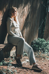 A girl on a bench is basking in the sun, not thinking about anything, enjoying the last days of autumn